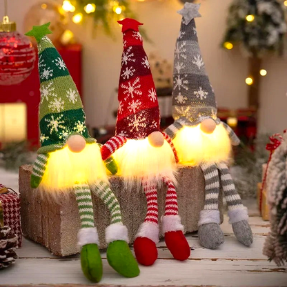 By Levin set of three plush LED Christmas gnomes with glowing beards, snowflake hats, and dangling striped legs.