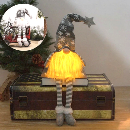 By Levin grey plush Christmas gnome with LED glowing beard, snowflake hat, and striped dangling legs on a trunk.