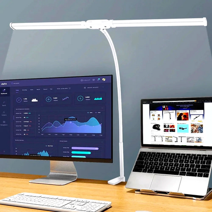 By Levin white double-head LED desk lamp with flexible gooseneck, illuminating a dual-monitor workspace.