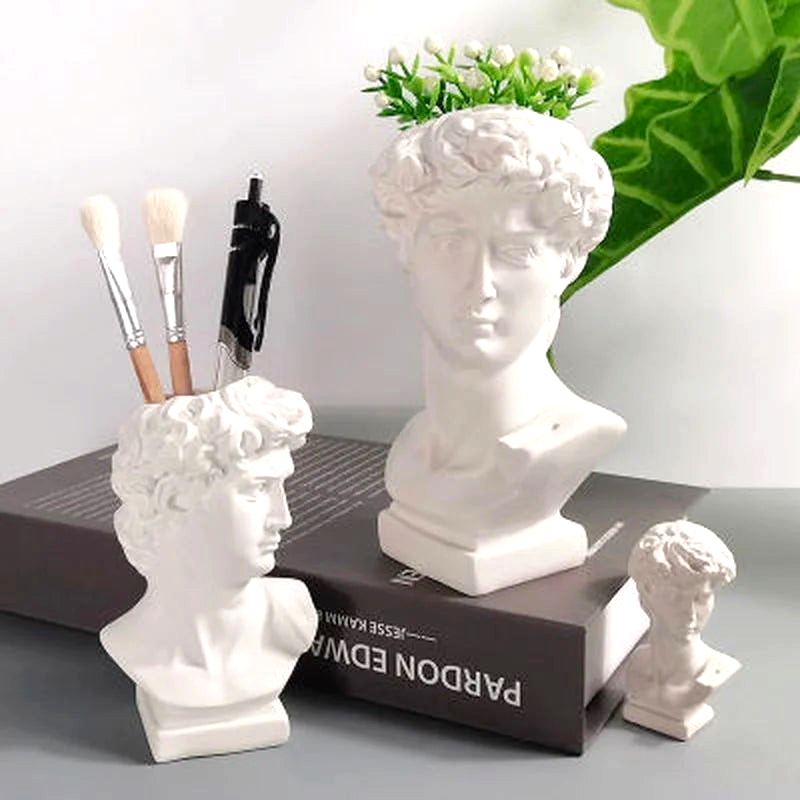 By Levin David bust resin vases and brush holders in various sizes displayed on a desk with brushes and flowers