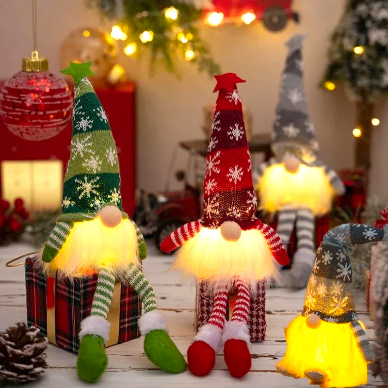By Levin LED Christmas gnomes with warm glowing beards, knitted snowflake hats, and dangling legs in festive decor.