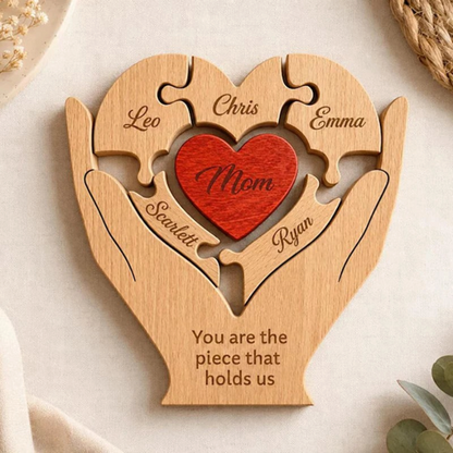 Gepersonaliseerde By Levin houten familie hart puzzel met gegraveerde namen en een rood hart in beschermende handen.