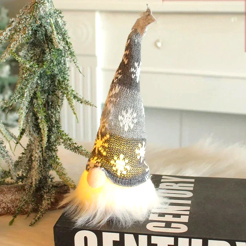 By Levin LED Christmas gnome with a grey knitted snowflake hat and glowing warm white light in its fluffy beard.