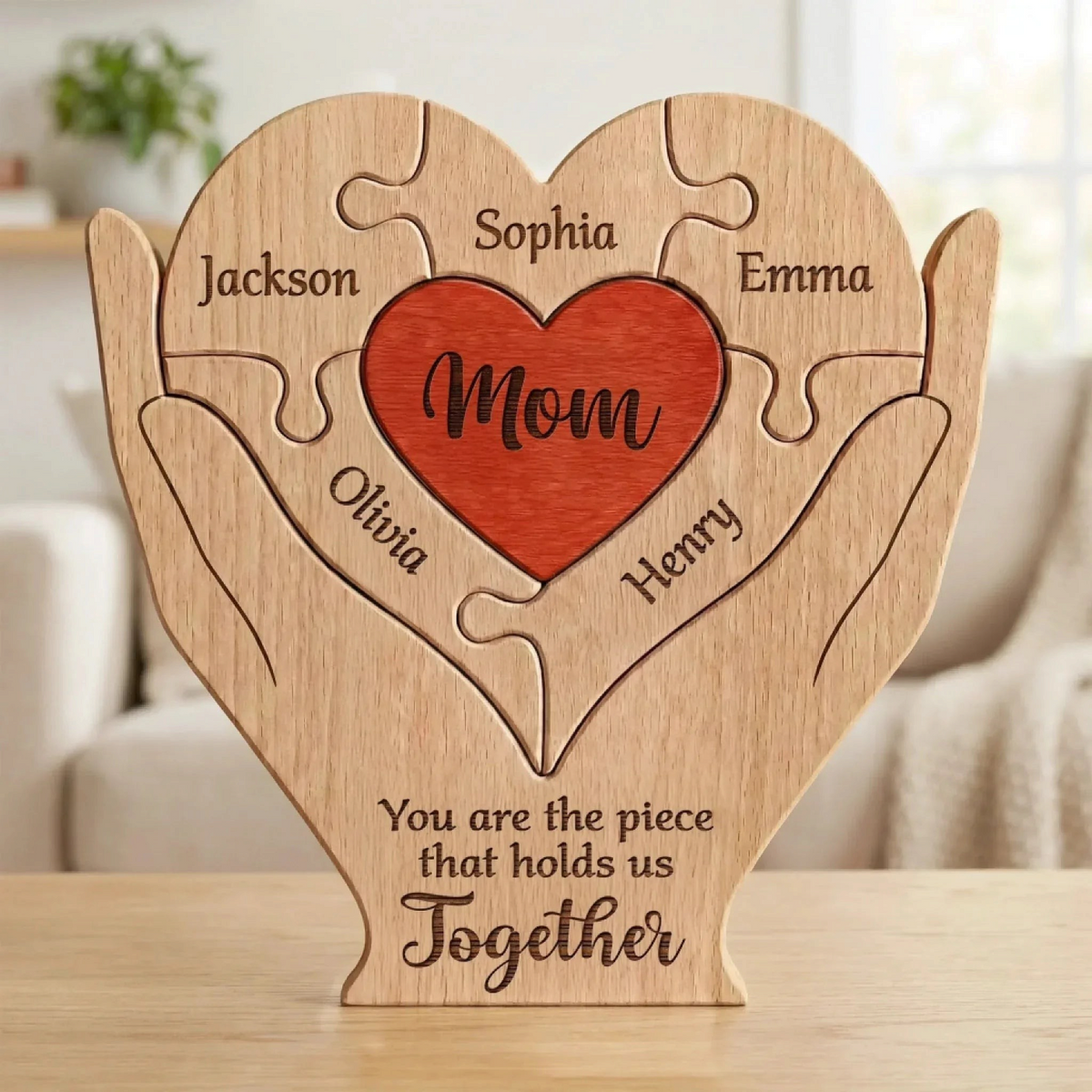 Gepersonaliseerde By Levin houten familie hart puzzel met gegraveerde namen en een rood hart in beschermende handen.